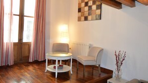 Une pièce dotée d’un plancher en bois, d’une table ronde avec une chaise, d’un radiateur et d’une œuvre d’art accrochée au mur.