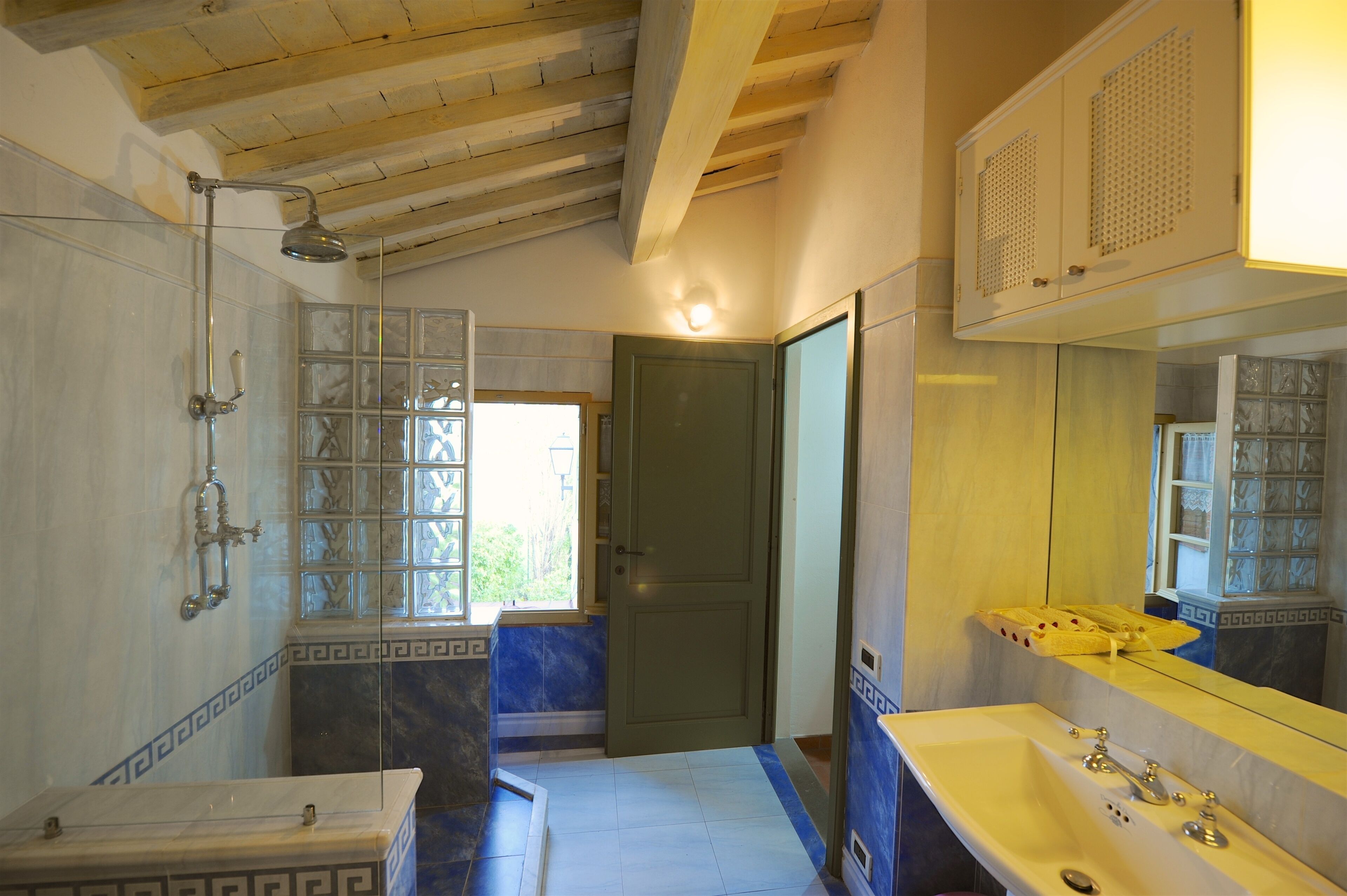 A bathroom with a bathtub, a shower, and a sink. There is a door leading to another room.