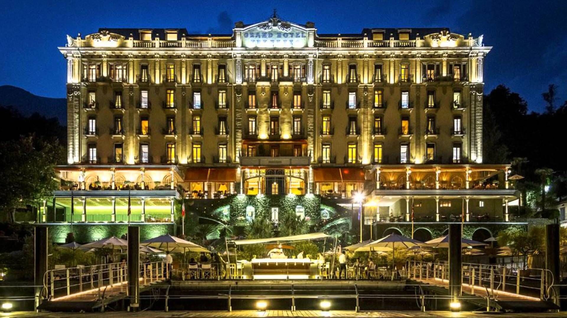 Ein imposantes Hotel mit mehreren Etagen, einem zentralen Innenhof und Außenbereichen mit Sitzgelegenheiten.