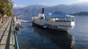 A boat docked at a pier with a clear view of mountains in the background.