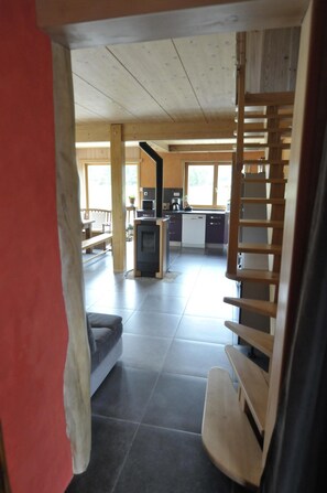 A spacious kitchen with modern appliances, a dining area with a bench, and a staircase leading to an upper level.
