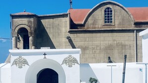 Ein Gebäude mit rotem Dach, einem großen Bogenportal und einem Glockenturm.