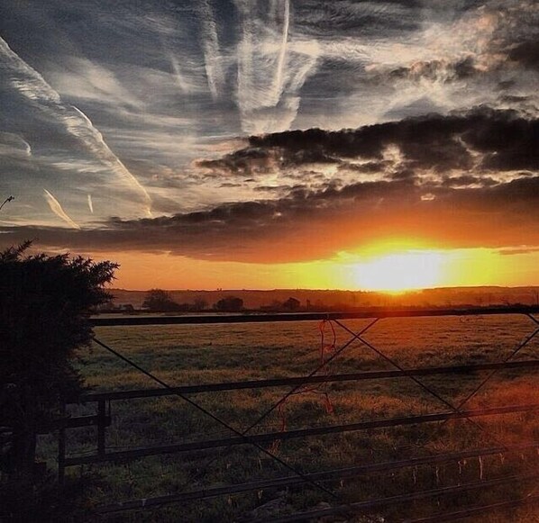 A sunset over a rural landscape with a fence in the foreground. - Beautifully Renovated Stable & Cart House | Peaceful West Wales Farm Stay (Hebron)
