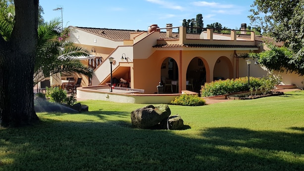 A building with a tiled roof, arched windows, and a well-maintained lawn with rocks and plants. - Villa Gilda, with last minute swimming pool t 03 - 21 September !!! (Pula)