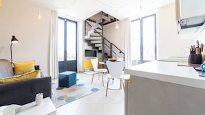 A modern living space with a staircase, a dining area, and a kitchen. - Suite Apartment Cavour- Exclusive"SunTripSicily" (Riposto)