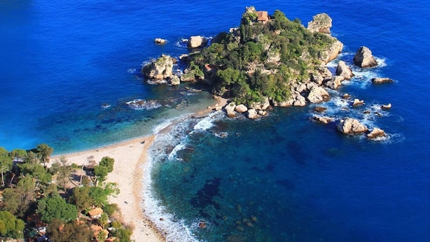 An aerial view of a coastal area with a small island featuring rocky terrain and a beach. - Suite Apartment Cavour- Exclusive"SunTripSicily" (Riposto)
