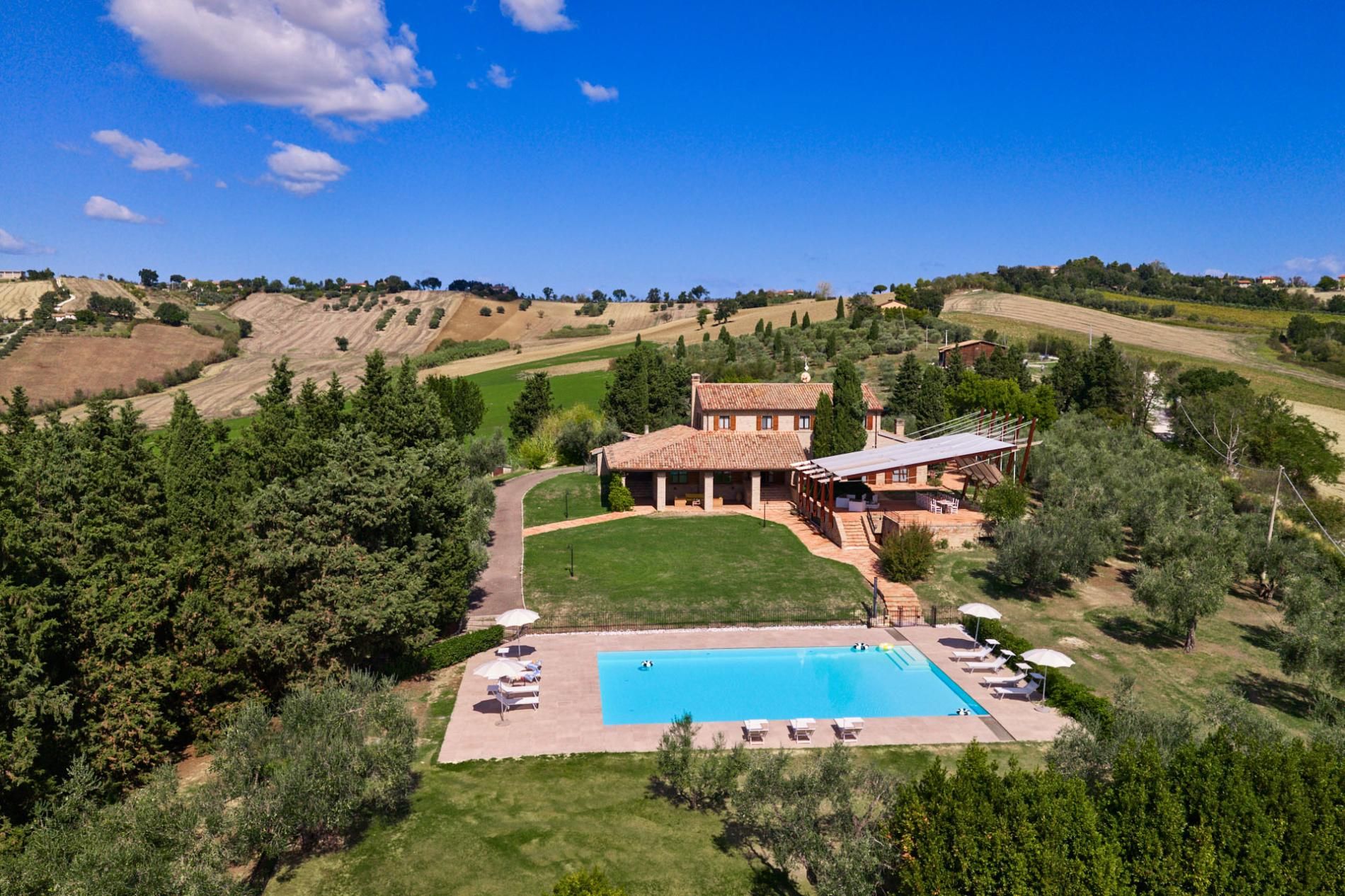 Una villa con piscina, immersa nel verde e circondata da dolci colline.