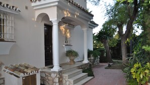 A building with a white facade, stone steps, and a tiled entrance.