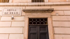 A building entrance with a black door, a sign reading "Vicolo R.V Di Febo", and the name "Giuseppe Vitelli" above the door. - 3 Bdr. Apt. Near Piazza Navona | 4 AC, WiFi, Heat (Roma)