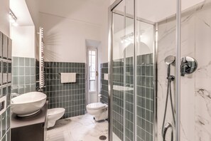 Kombination af bruser/badekar, hårtørrer, bidet, håndklæder