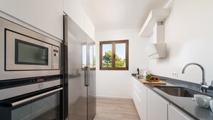 Une cuisine moderne dotée d’appareils électroménagers en acier inoxydable, d’une fenêtre et d’un évier.