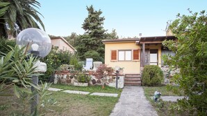 A small house with a stone wall and a garden path leading to the entrance. - VILLETTA BEL GIARDINO (MARINA DI CAMPO)