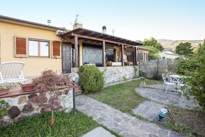 Una casa con un vialetto in pietra che conduce a un patio con mobili da esterno.
