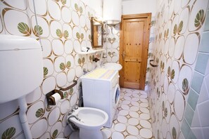 A bathroom with a toilet, sink, and washing machine.