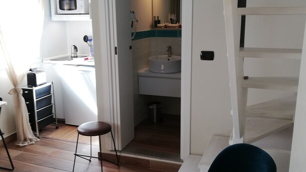 Un espacio habitable compacto con kitchenette, baño y comedor.