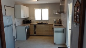 A compact kitchen with a refrigerator, microwave, sink, and a coffee maker.