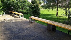 Un parque con bancos de hormigón y un sendero de grava.