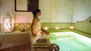 A spa room with a bathtub, towels, a lantern, and candles. - Delicious Villa with wellness center and private pool (Camaiore)