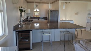 A modern kitchen with a central island, stainless steel appliances, and pendant lighting. - A Luxurious Place To Chill Out In Barbados (Mount Standfast)