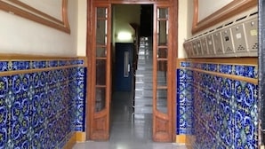 A hallway with ornate wooden doors and blue patterned tiles. - APARTMENT BARCELONA near BEACH (Barcelona)
