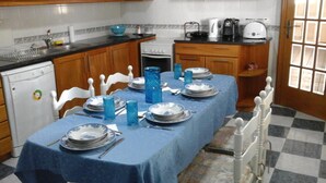 Une cuisine avec une table à manger dressée pour quatre personnes, équipée d’assiettes, de verres et de couverts.