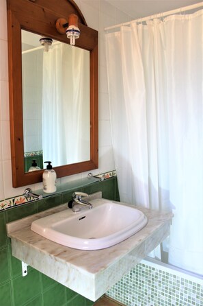 Een bad/douchecombinatie, een haardroger, een bidet, handdoeken