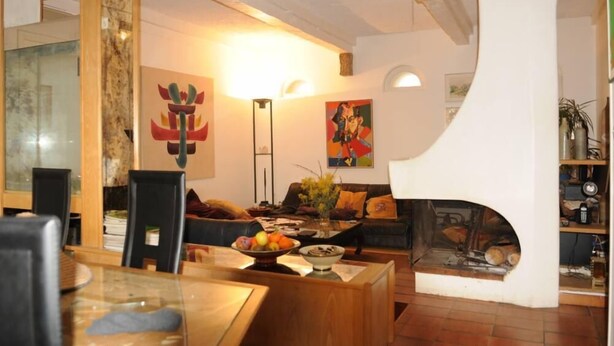 Un salon moderne avec une cheminée, un coin repas et un grand miroir.