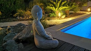 A stone Buddha statue by a poolside. - Lovely villa, near town, huge 76m2 pool, see the video ! (Javea)