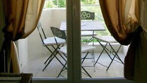 A room with a sliding glass door leading to an outdoor area with a table and chairs. - Lovely Apartment in Nice - Book now for great Prices! (Nice)