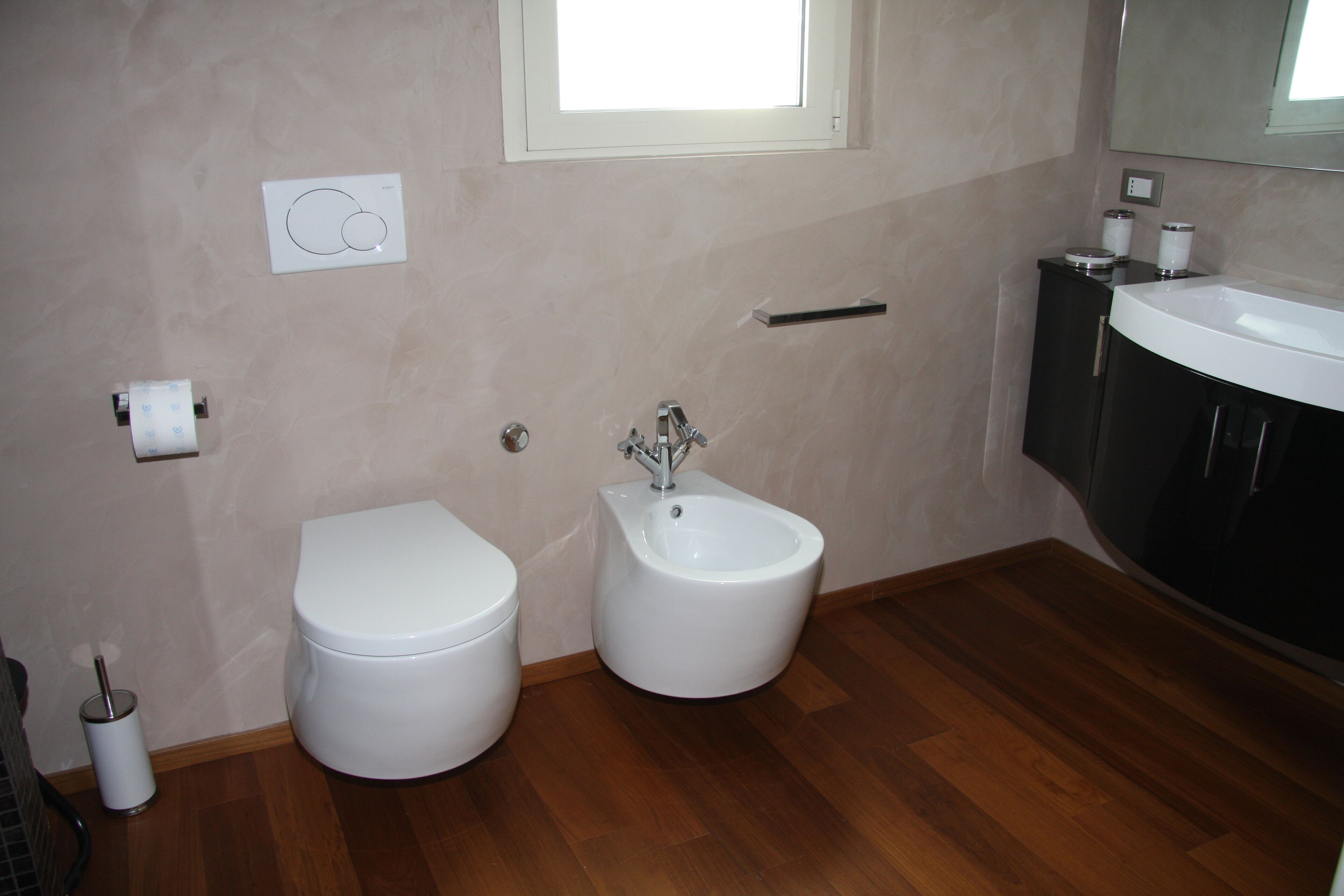 A bathroom with a toilet, bidet, and sink.