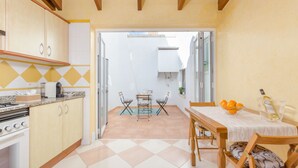 A kitchen with a dining area, featuring a stove, cabinets, and a table with chairs. - ROSER (ROSER DE ARTÀ) - Townhouse with terrace in Artà. Free WiFi (Artà)