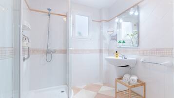 Een bad/douchecombinatie, een haardroger, een bidet, handdoeken