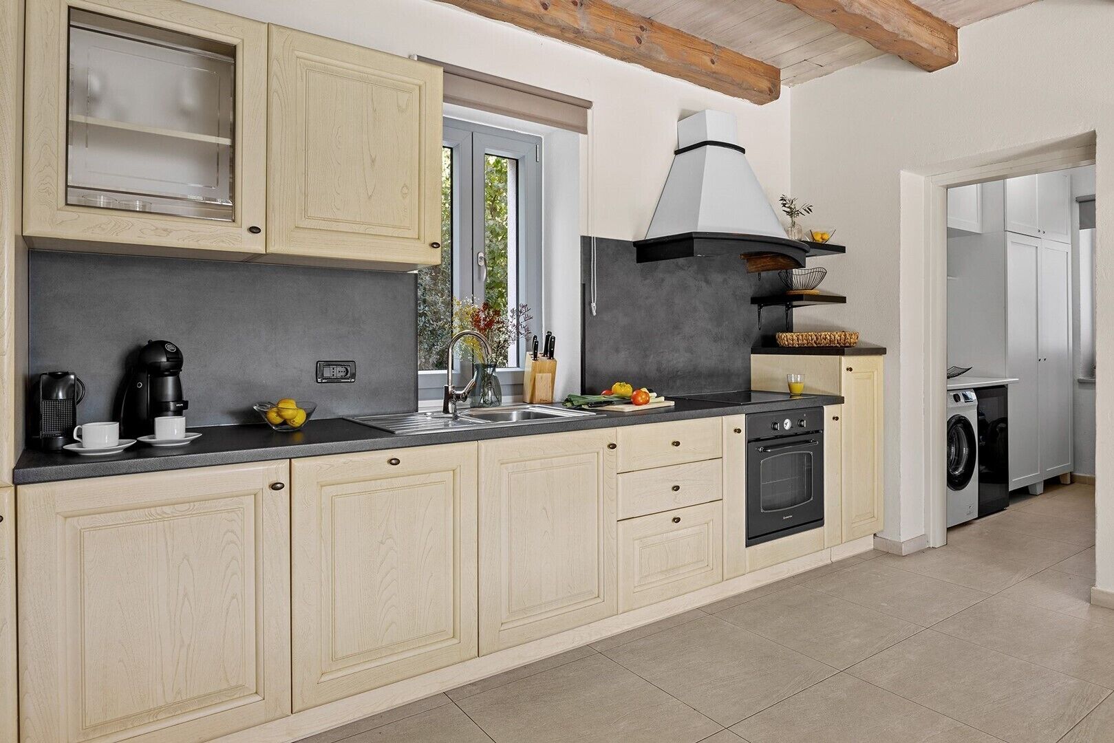 A modern kitchen with a built-in oven, a coffee maker, and a sink.