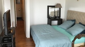A bedroom with a bed, a nightstand, a lamp, and a television. - Pau facing the Pyrenees (Pau)