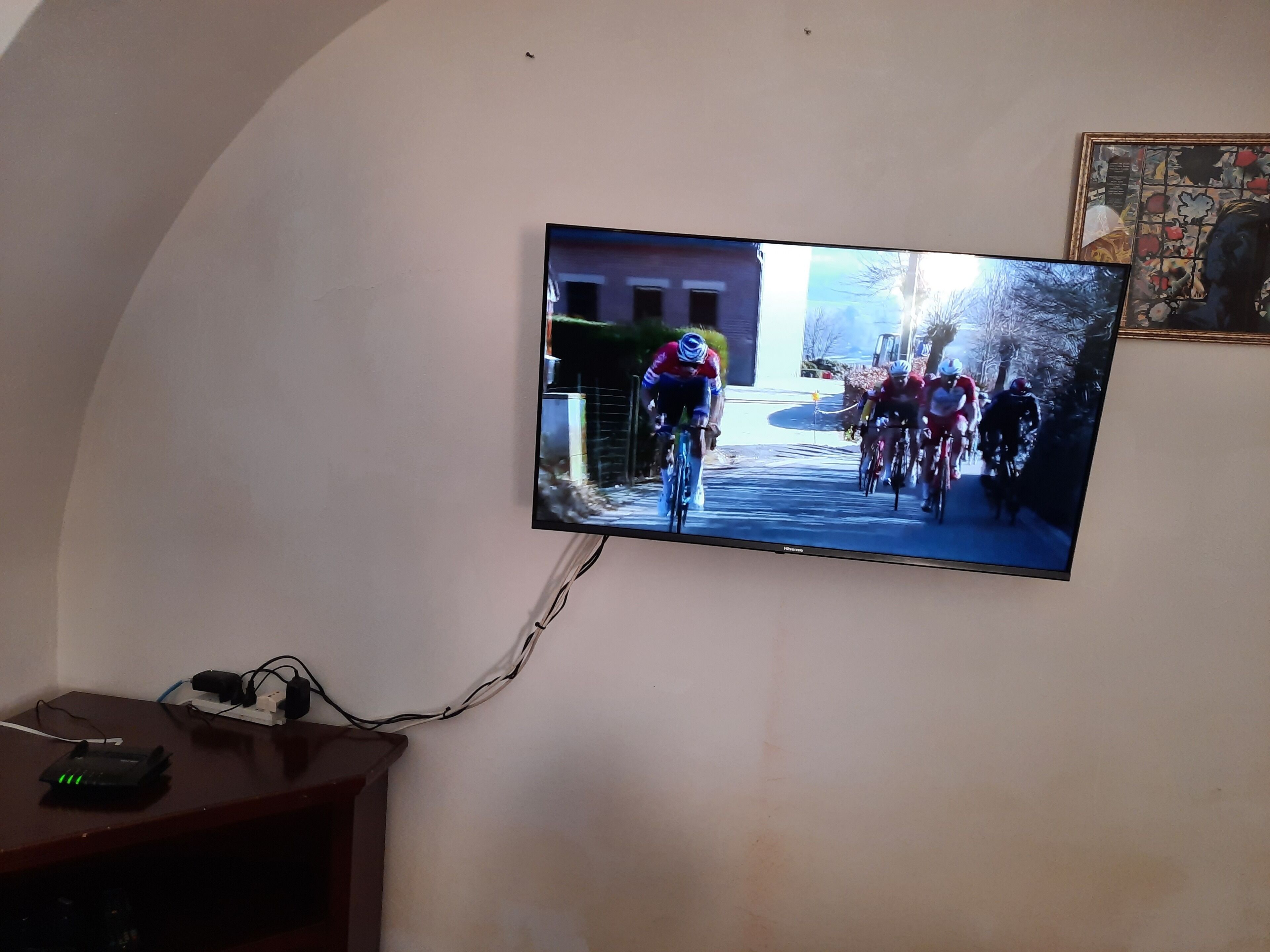 Televisie aan de muur met een fietsevenement.