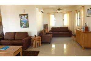 A living room with two sofas, a coffee table, and a cabinet. - Private Villa, stunning views, pool, Hottub,Ideal Base to explore the West Coast (Theletra)