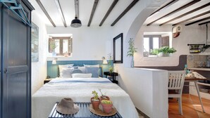 A bedroom with a bed, bedside tables, a window, and a view of the outside. - Refurbished holiday apartment in an Andalusian farmhouse in The Lake District (Antequera)