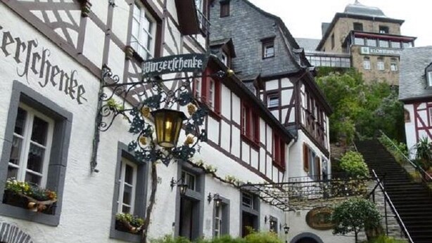 Un edificio tradicional de entramado de madera con un letrero que dice 'Wirtshaus'.