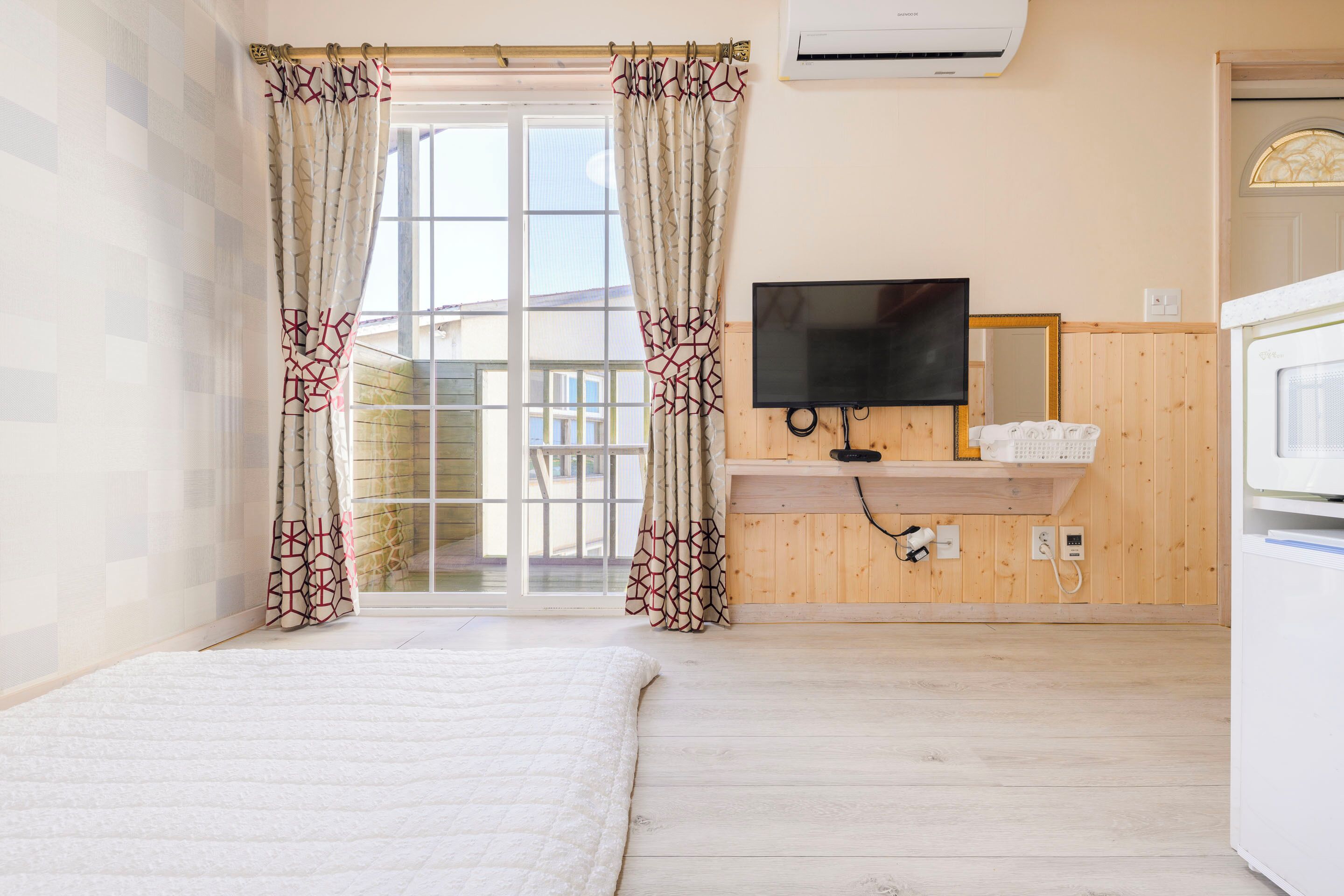 Ein Zimmer mit einem Bett, einem Fernseher und einer Holzwand.