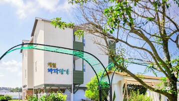 A building with a sign that reads "아일랜드" and a green archway in front.