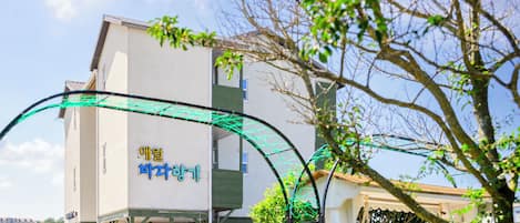 A building with a sign that reads "아일랜드" and a green archway in front.
