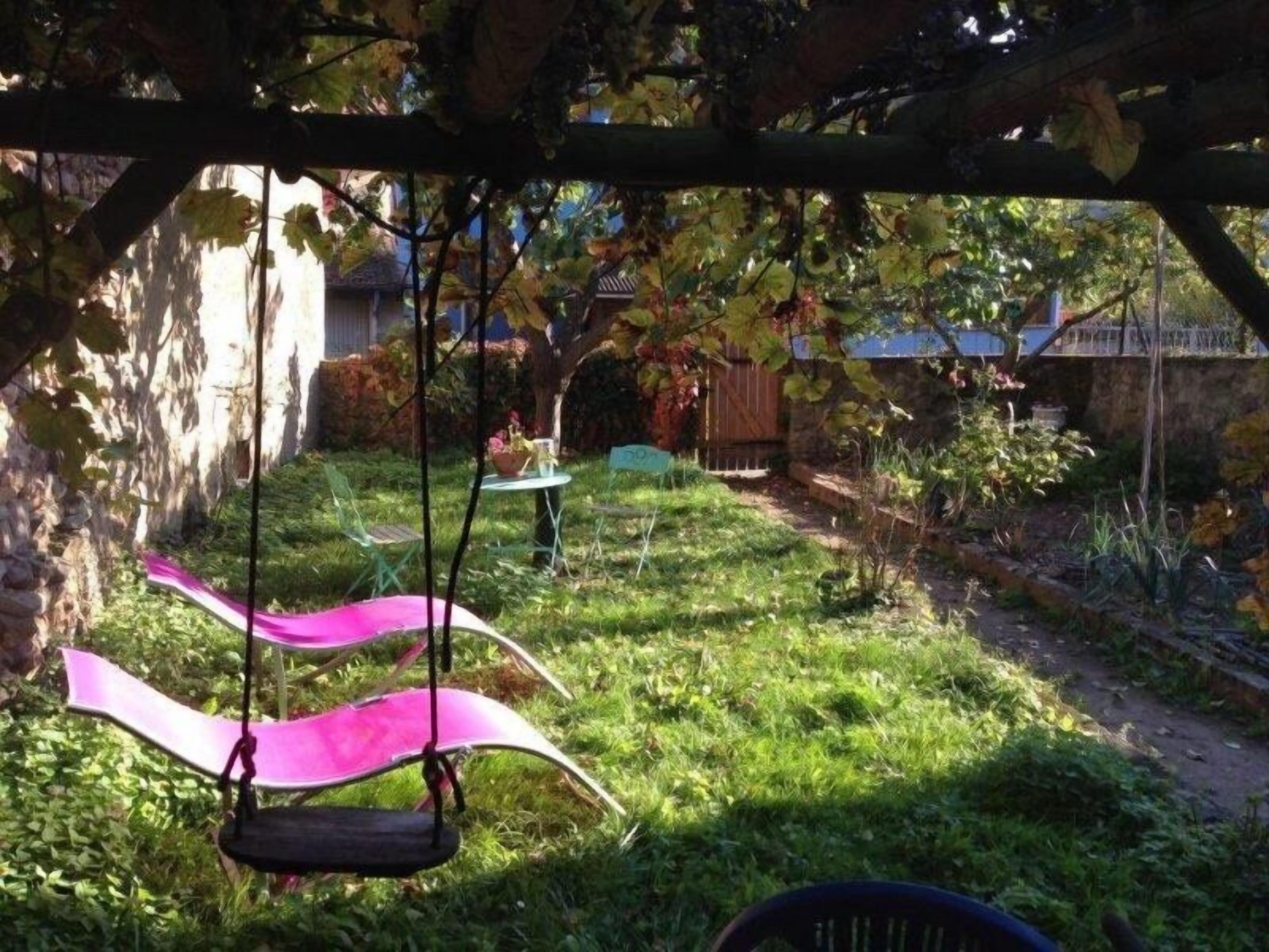 Un jardin avec une balançoire et une table.