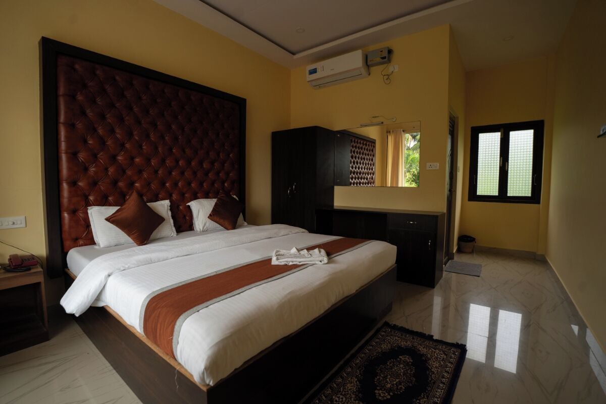 Habitación de hotel con una cama grande, un armario, aire acondicionado y una ventana con persianas.