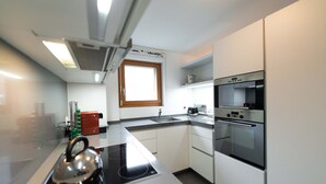 A modern kitchen with a built-in stove, oven, and sink. - 6 min from the center and the MatterhornParadise station, next to the ski bus stop (Zermatt)