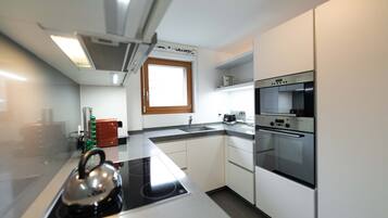 A modern kitchen with a built-in stove, oven, and sink.