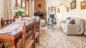 A cozy living room with a brick fireplace, wooden furniture, and a variety of decorative items. - Holiday house with pool, air conditioning in the bedrooms, internet / outside kitchen with barbecue, (Pollensa)
