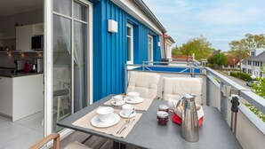 A balcony with a table set for two, a coffee pot, and a red kettle. - Flooded with light, close to the center, WLAN, 400 m z. Beach (Zingst)