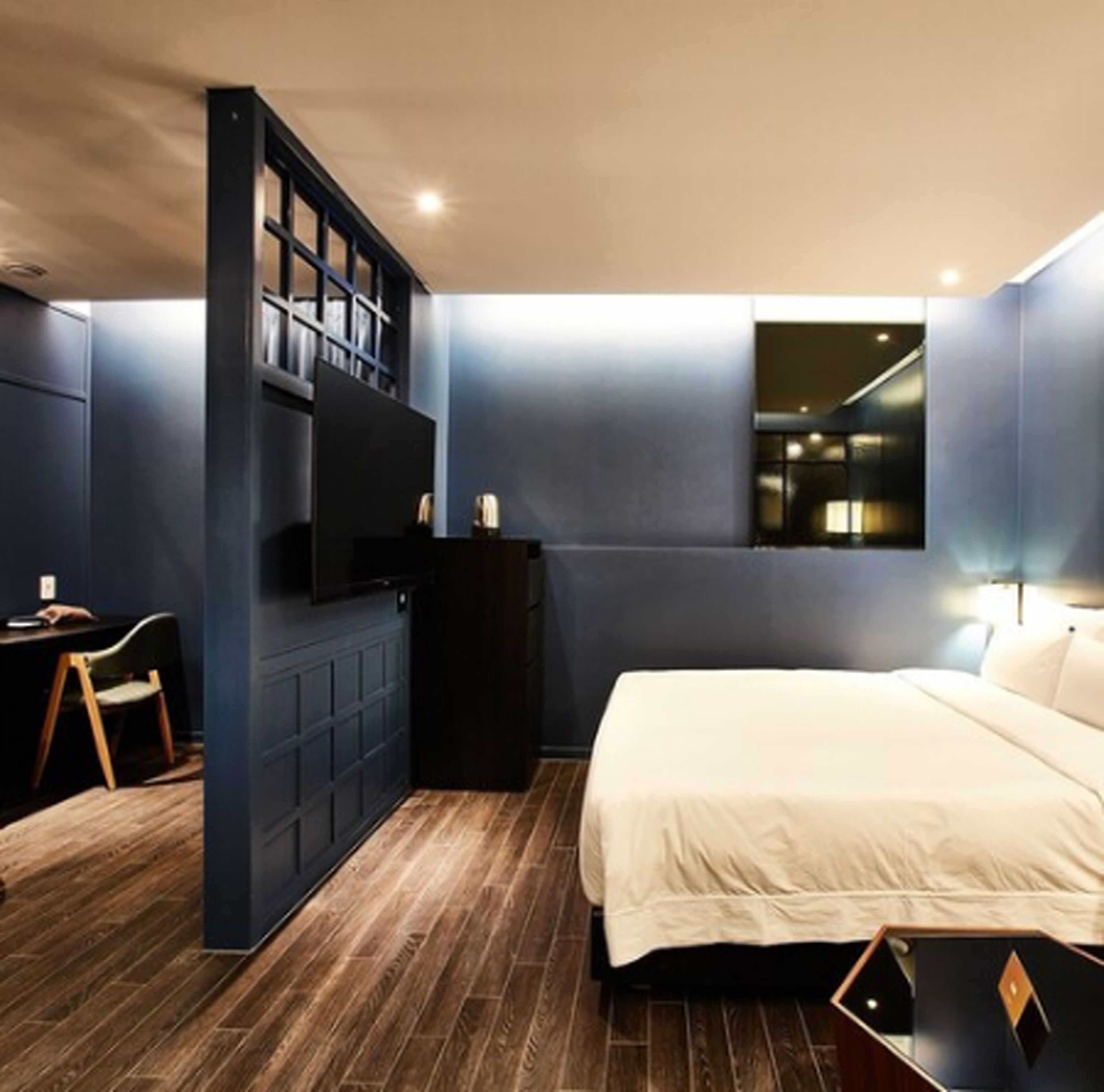 Ein modernes Schlafzimmer mit einem großen Bett, einem Schreibtisch und einer integrierten Regaleinheit.