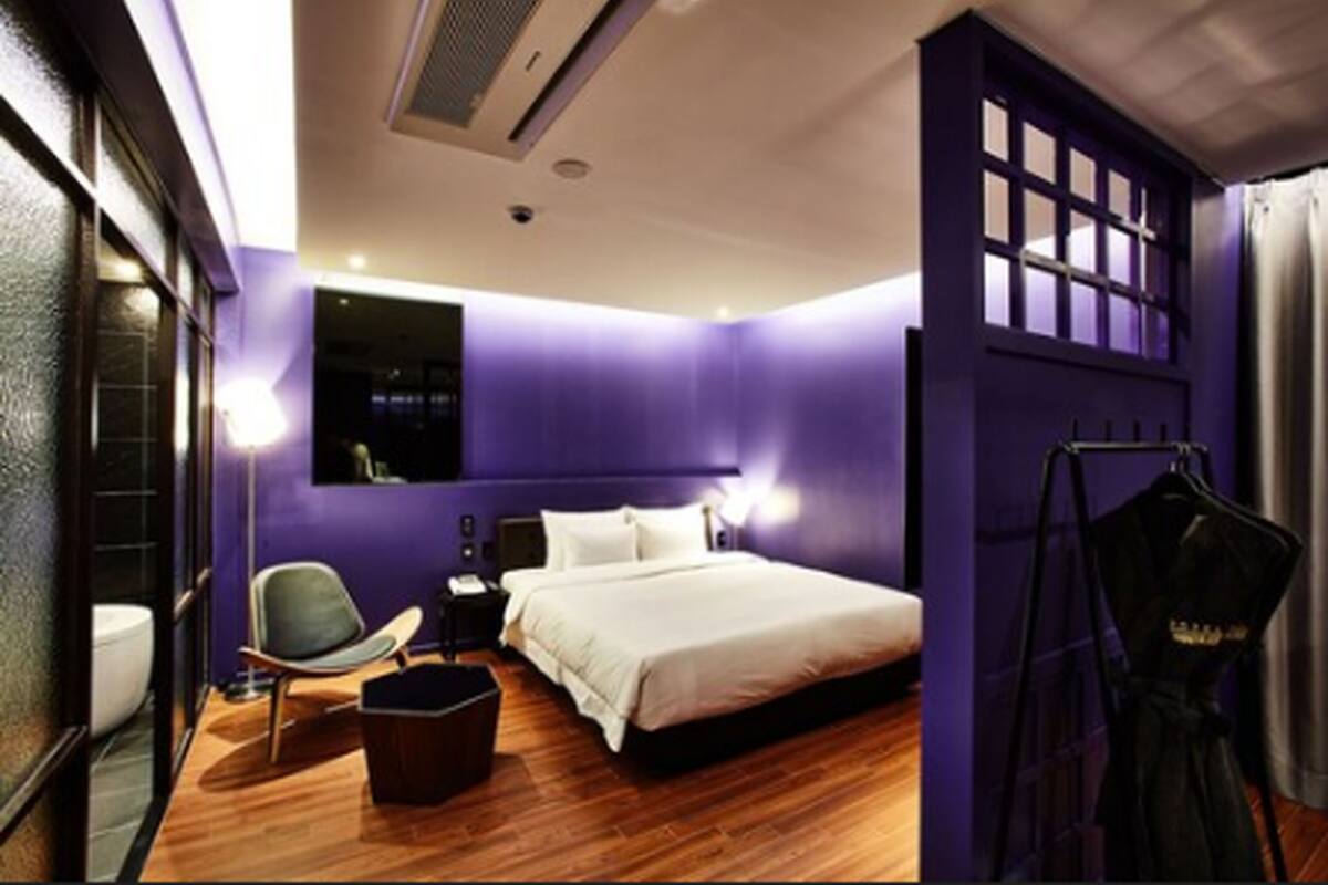 Une chambre à coucher moderne avec un grand lit, une chaise et une armoire.