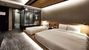 Quarto de hotel com duas camas, cabeceira de madeira, guarda-roupa embutido e chão de mármore.